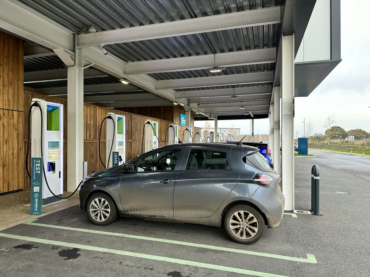 A car at a charging bay on a modern forecourt