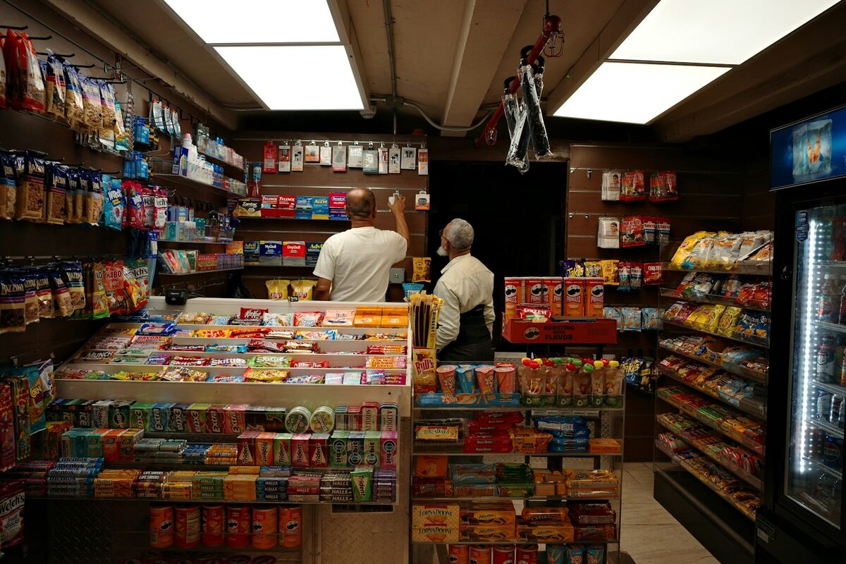 Two members of staff behind the counter of a small shop